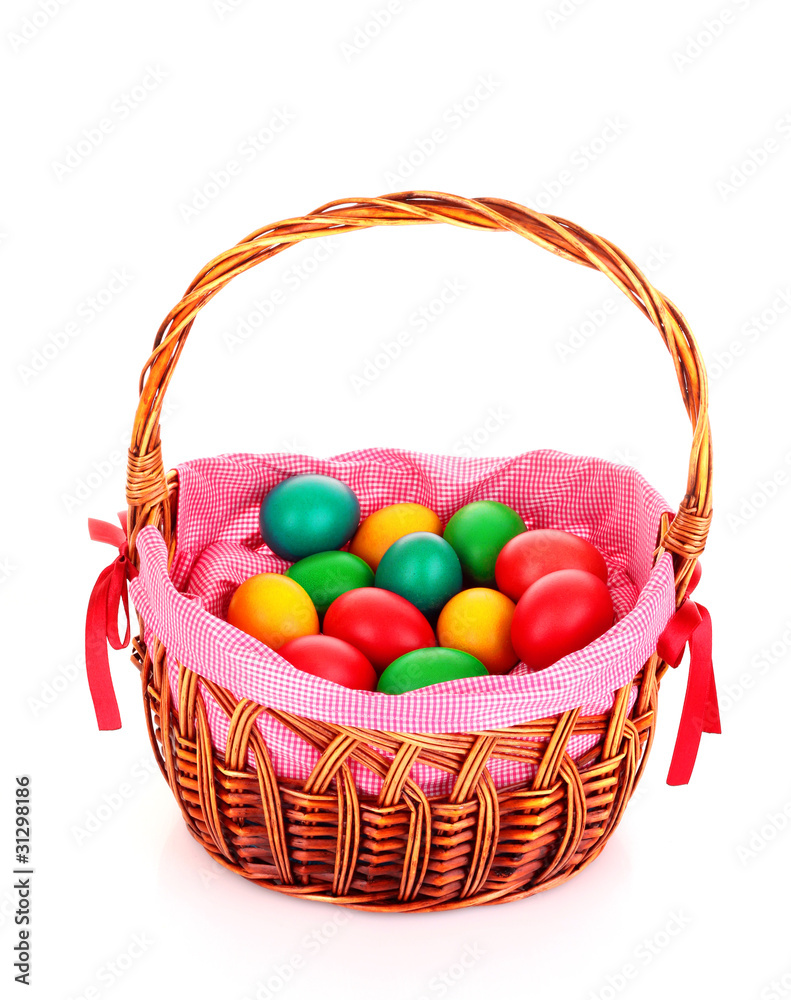 Naklejka premium Wicker basket with Easter eggs isolated on white