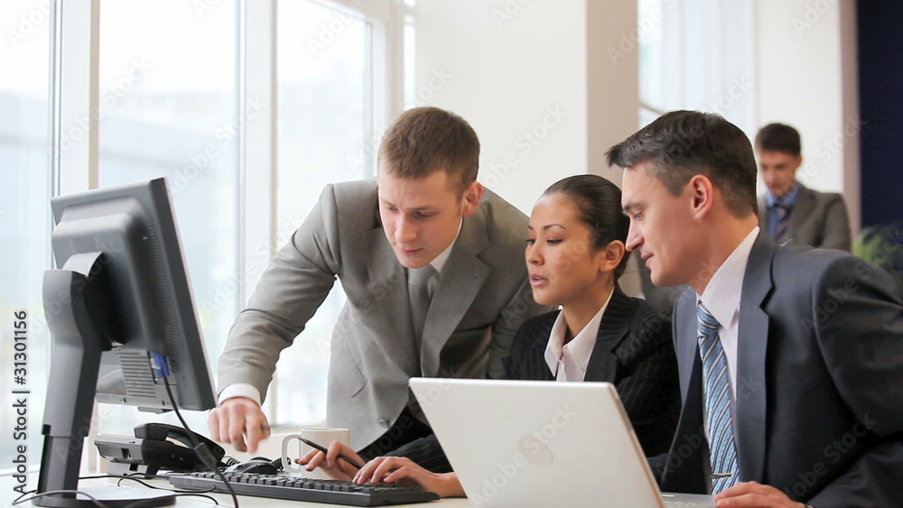 Businesspeople looking at monitor of computer and talking Businesspeople looking at monitor of computer and talking