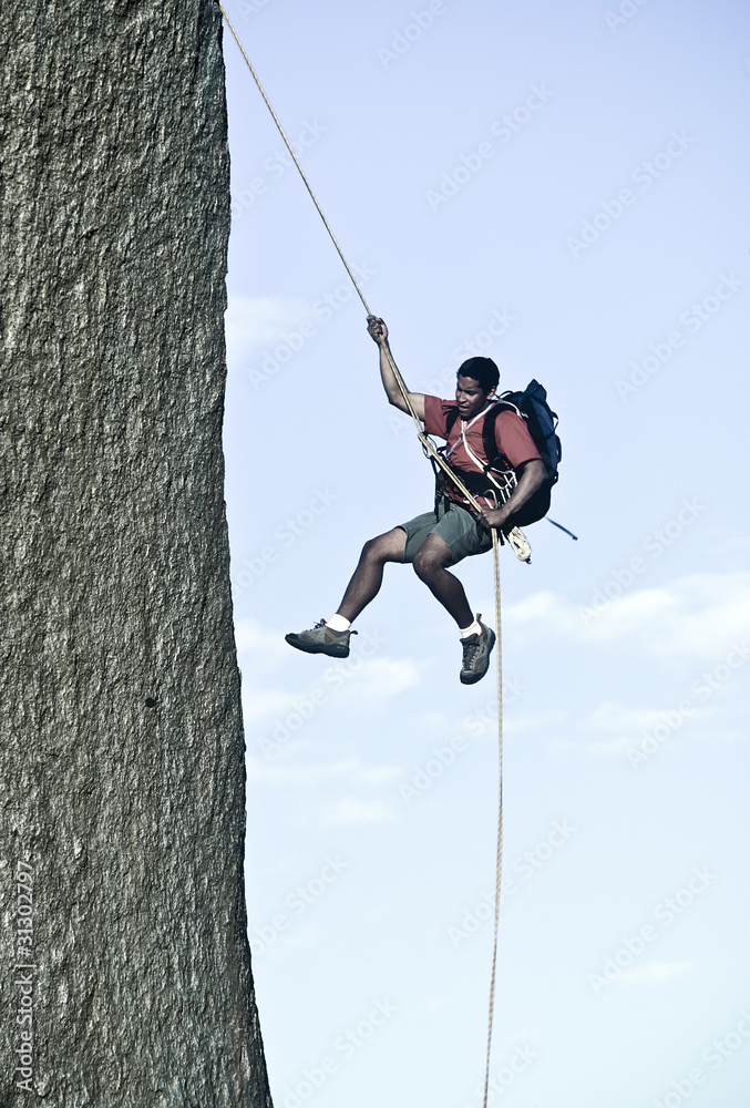 Rock climber rappelling. Rock climber rappelling.
