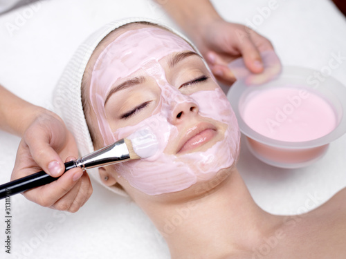 Girl receiving cosmetic pink facial mask #31311707