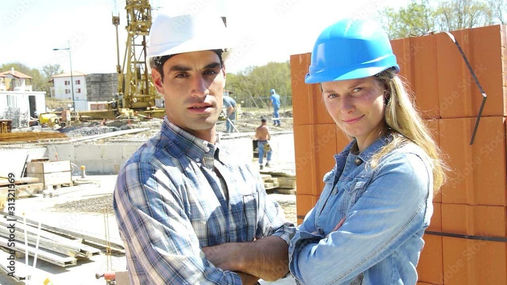 Engineers standing on construction site with arms crossed Engineers standing on construction site with arms crossed