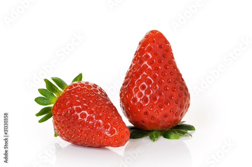 two ripe strawberries with big leaves on white background