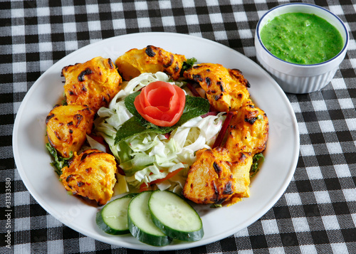 Chicken tikka with salad in plate photo