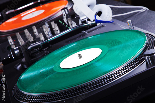 Schallplattenspieler im Disco Licht, grüne und rote Platte Nahaufnahme