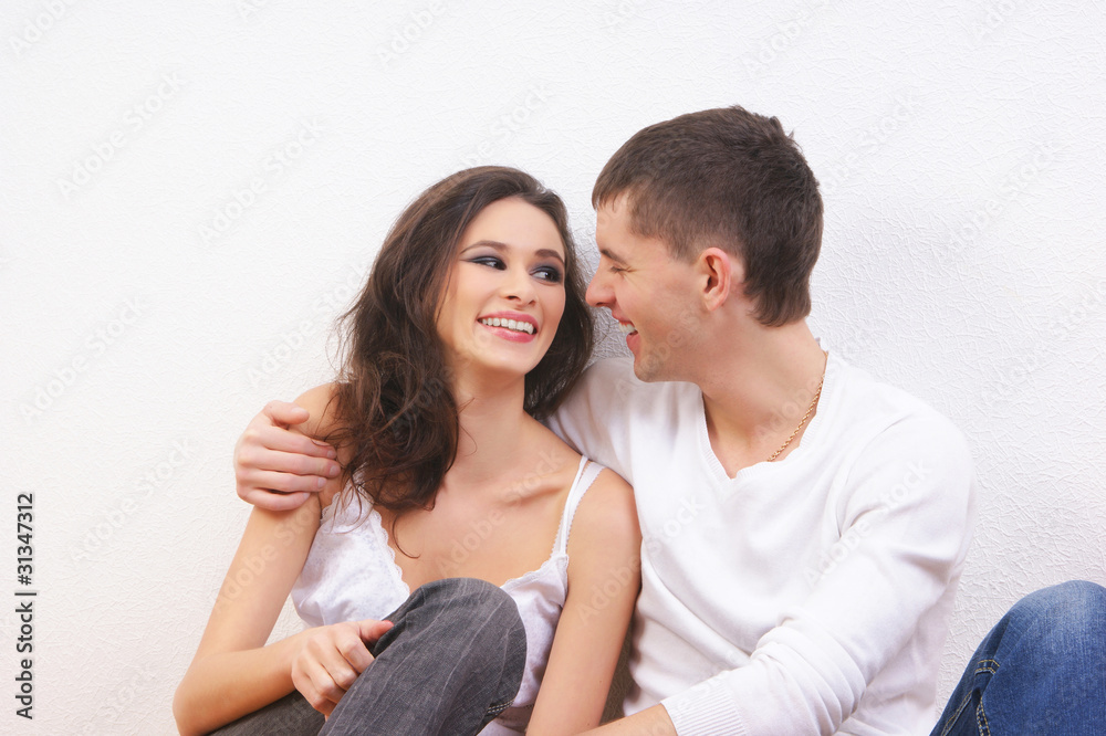 A beautiful couple of two young lovers on a light background