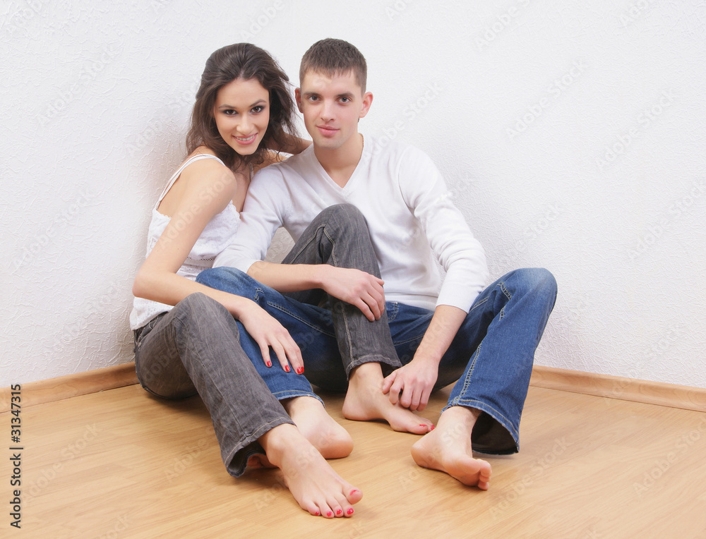 A beautiful couple of two young lovers on a light background A beautiful couple of two young lovers on a light background
