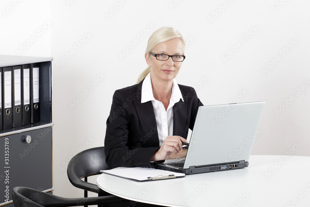 Frau am Schreibtisch mit Laptop zuversichtlich Frau am Schreibtisch mit Laptop zuversichtlich