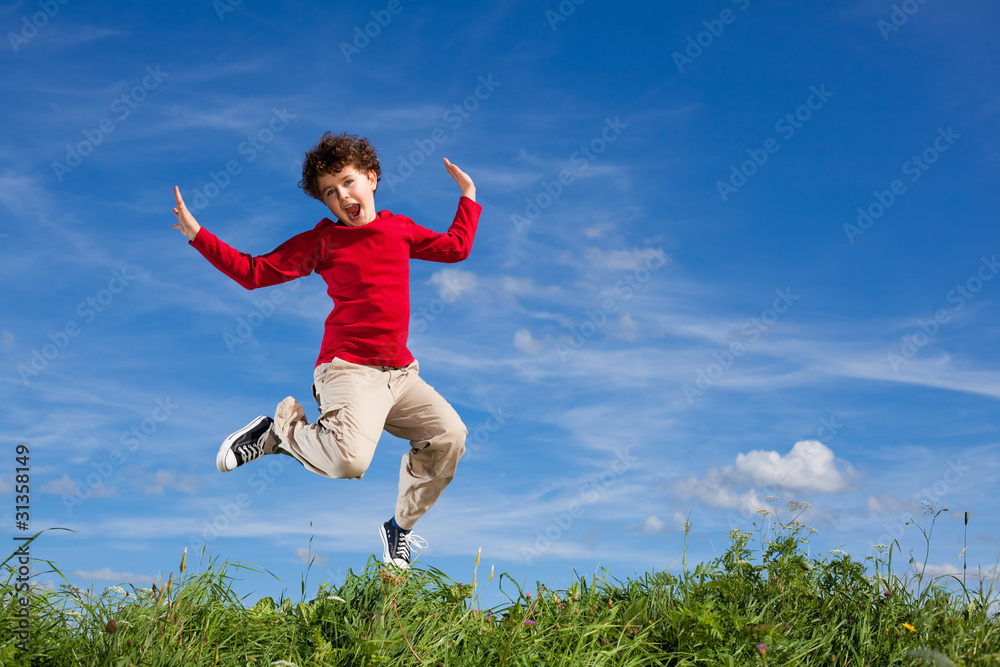 Boy jumping, running against blue sky Boy jumping, running against blue sky