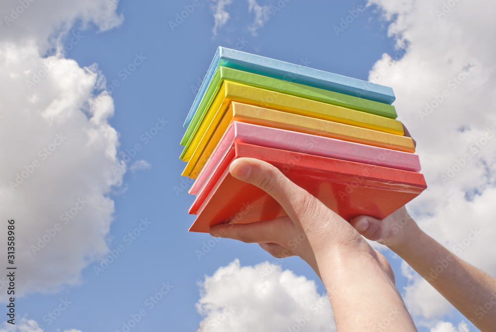 Hands holding color hard cover books