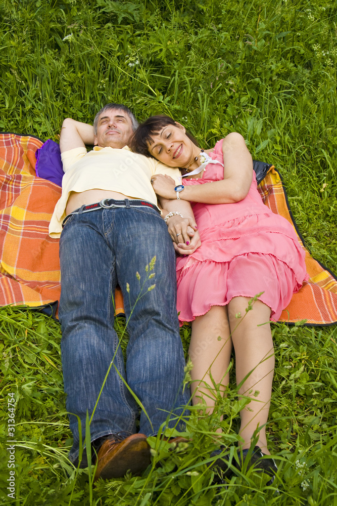 Fototapeta premium Couple sleeping on grass