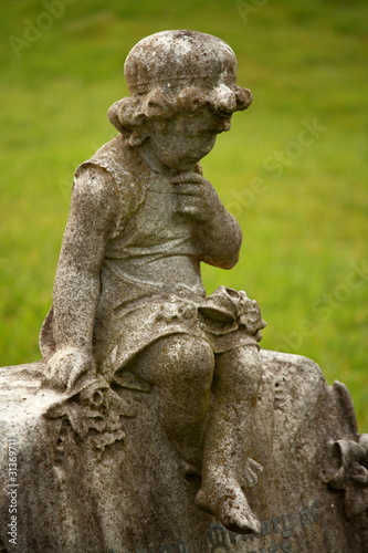 detail of little girl statue on gravestone