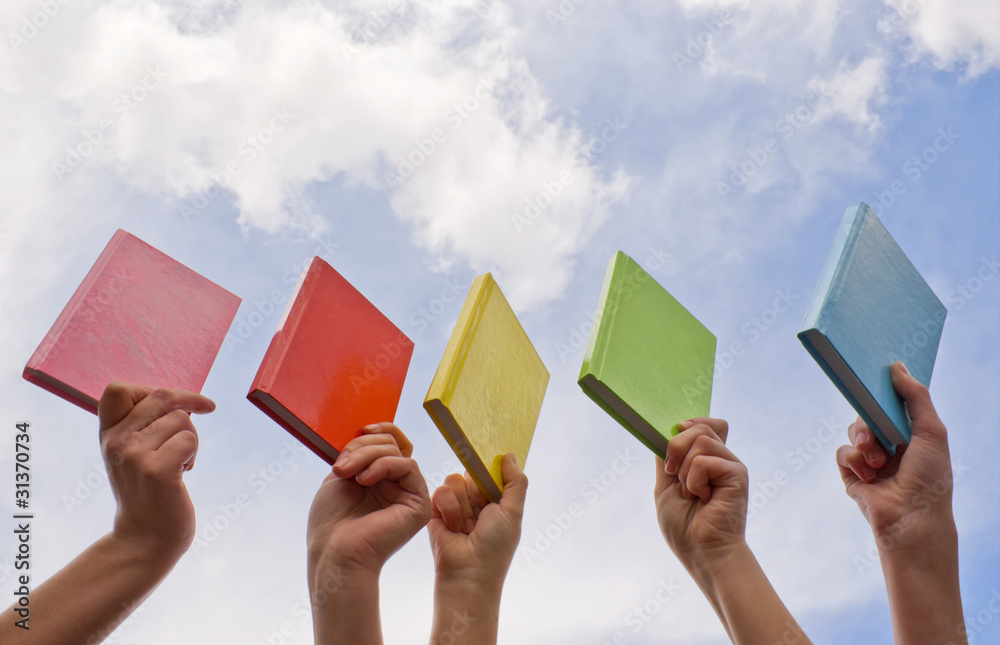 Hands holding color hard cover books