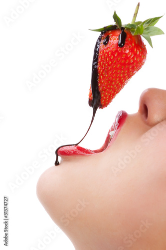 girl eating strawberry with chocolate sauc photo