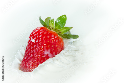 strawberry splashing into milk