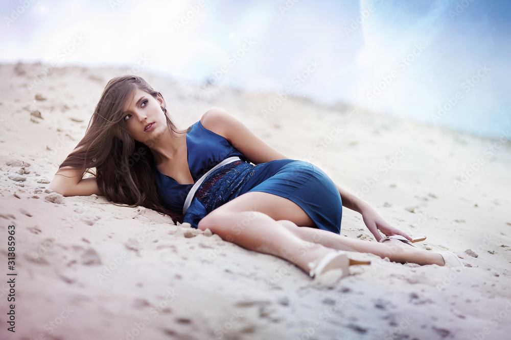 Sexual woman in blue dress laying on the cosmic beach Sexual woman in blue dress laying on the cosmic beach