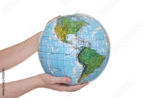 Hands holding an inflatable globe showing the American continent