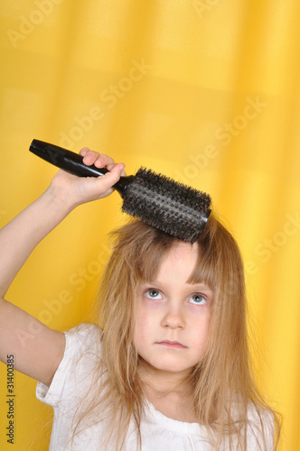 girl treying to brush her hair