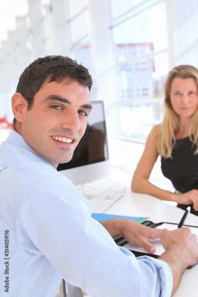 Man in office signing contract Man in office signing contract