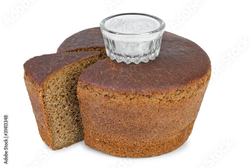 Cut loaf of round rye bread and salt jar