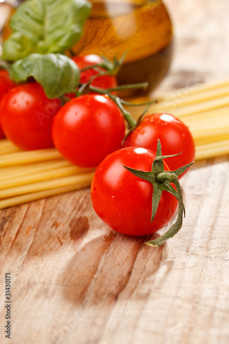 pasta, olive oil and tomatoes on the wood background