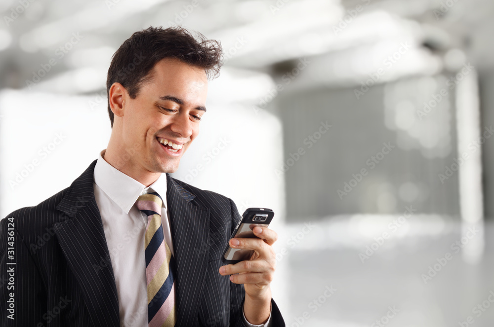 Smiling businessman reading an sms Smiling businessman reading an sms
