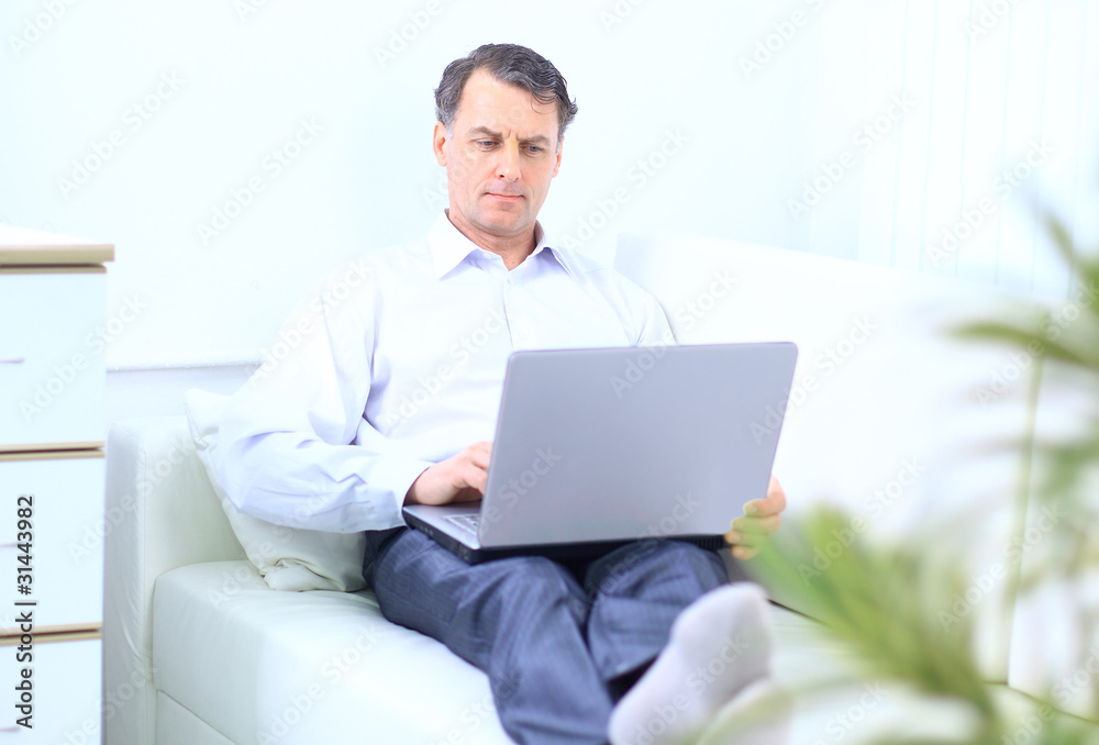Senior man in sofa with laptop computer Senior man in sofa with laptop computer