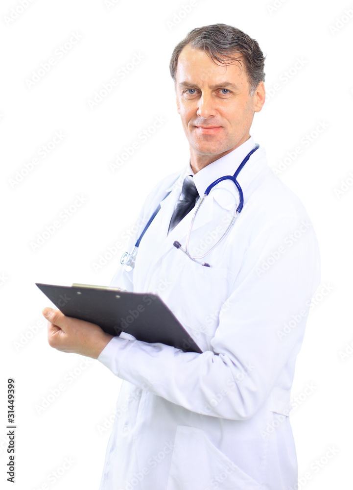 Happy smiling mature doctor writing on clipboard in a Happy smiling mature doctor writing on clipboard in a