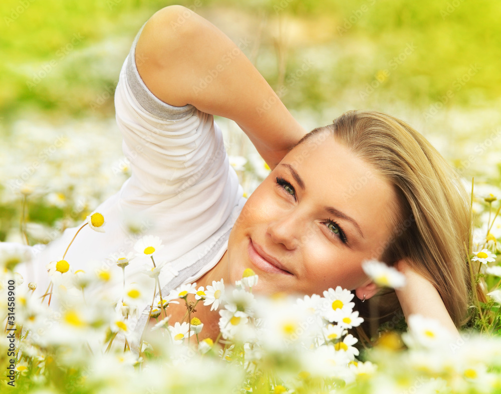 Beautiful female laying on the flower filed Beautiful female laying on the flower filed