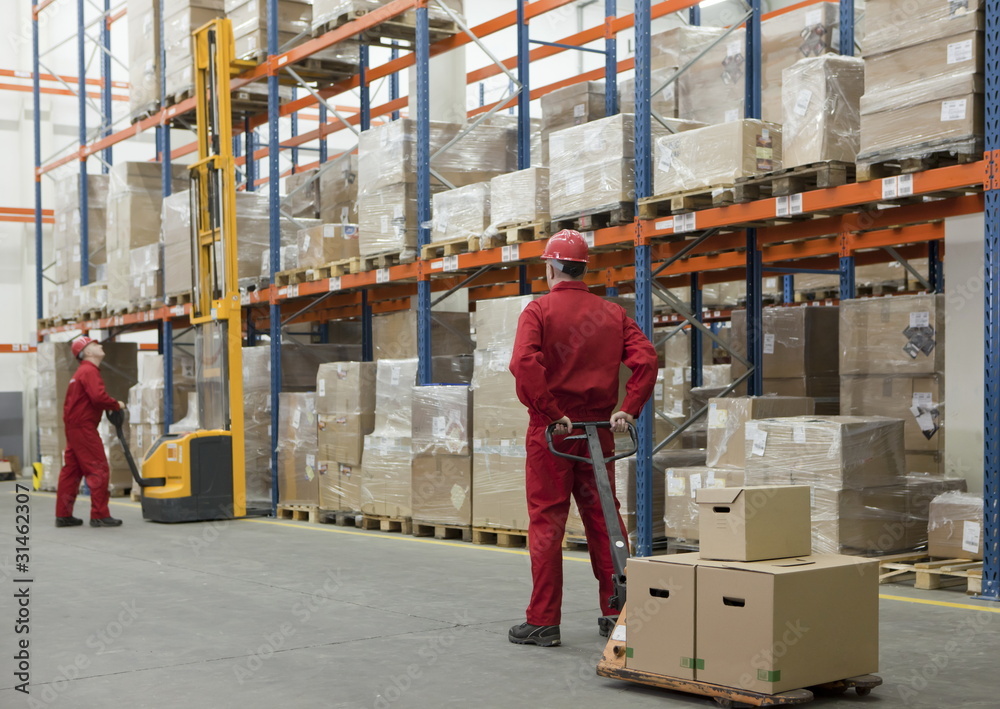 workers in uniforms and safety helmets working in storehouse workers in uniforms and safety helmets working in storehouse