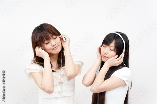 two beautiful asian women listening to music
