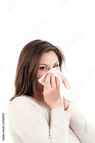Junge Frau schneuzt in Taschentuch photo