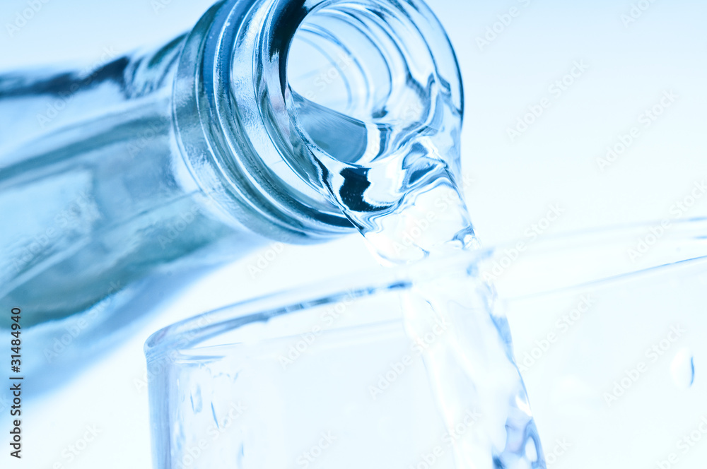 bottle pouring water into glass