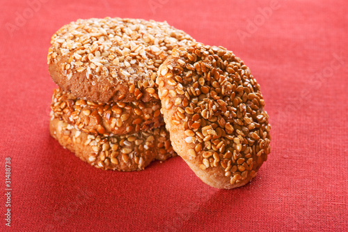 cookies with sesame seedson on red photo