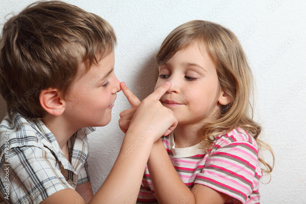 Portrait of playful girl and boy, they put fingers on nose Portrait of playful girl and boy, they put fingers on nose