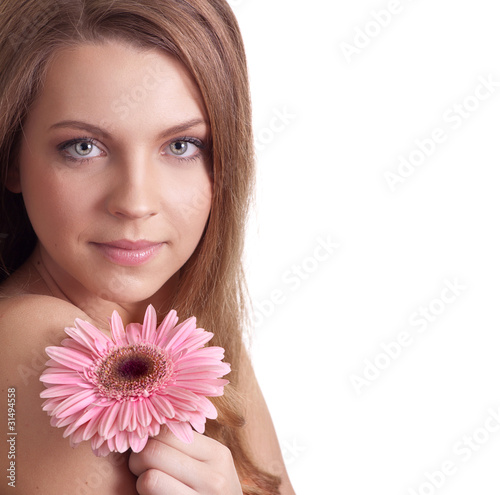 closeup of a pretty young woman smelling a pink flower