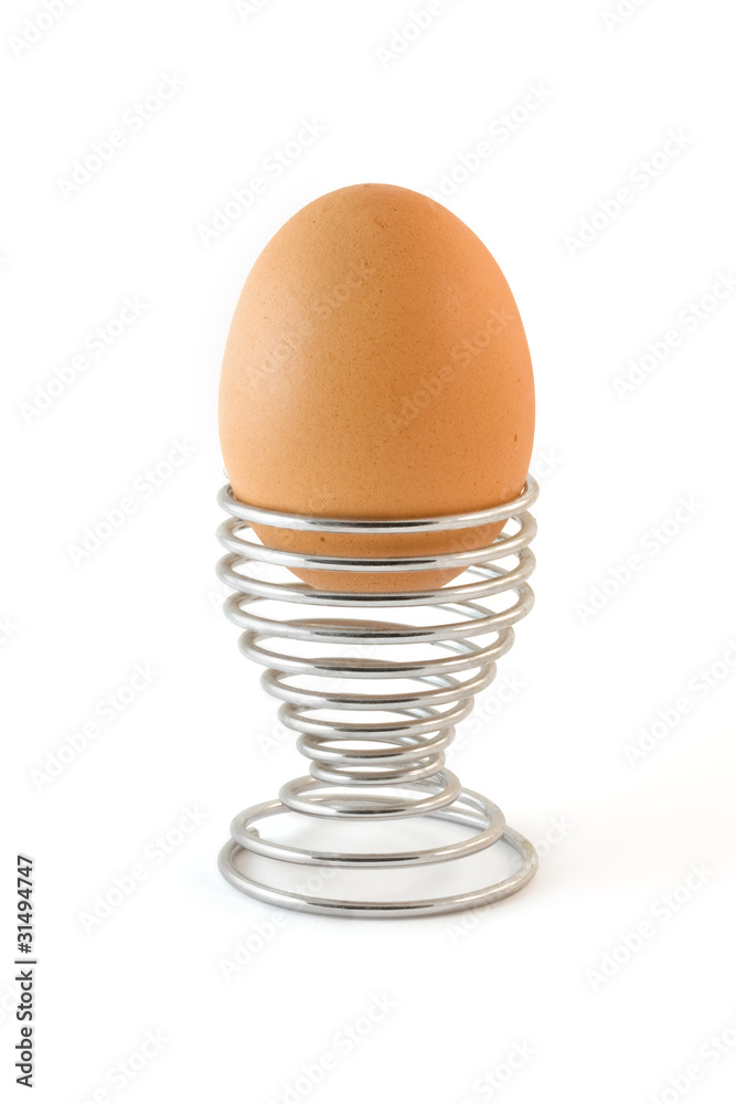 Isolated boiled egg in metal egg cup Isolated boiled egg in metal egg cup