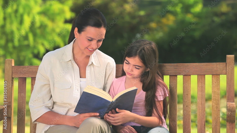 Mother with her daughter reading a book Mother with her daughter reading a book