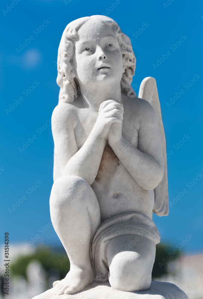 Praying infant angel with a blue sky background