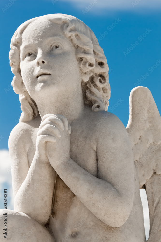 Praying angel with a blue sky background