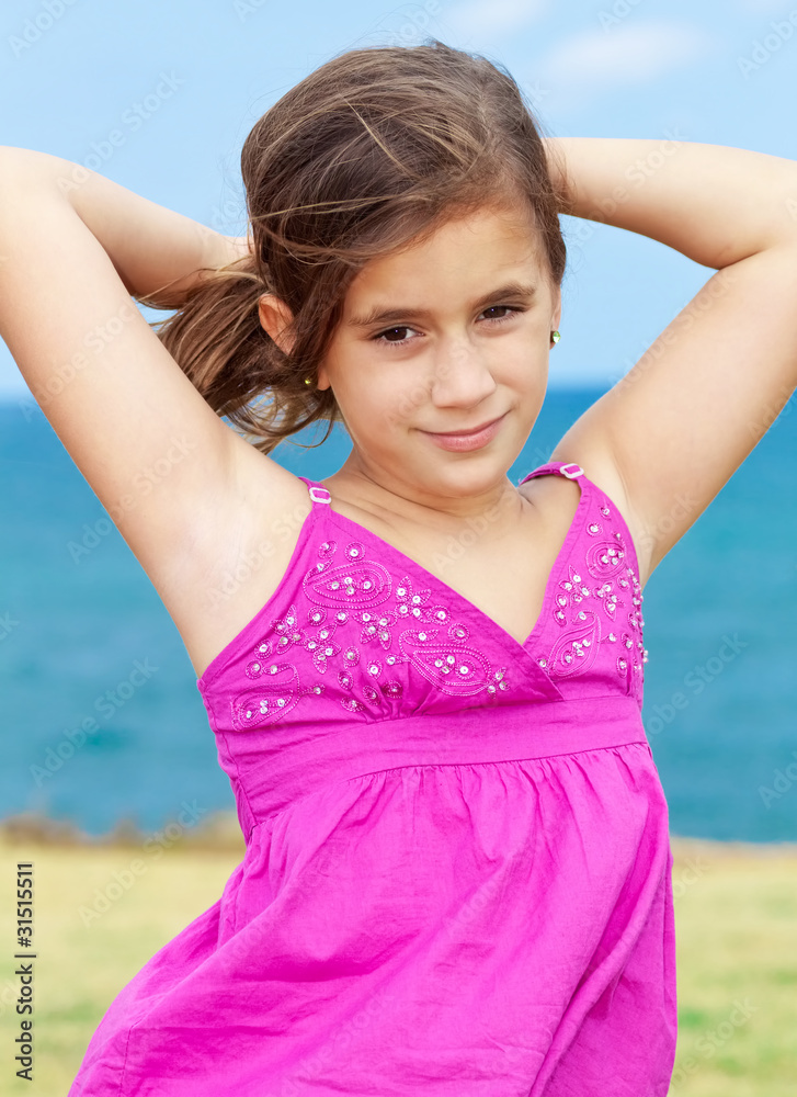 Beautiful girl wearing a magenta dress smiling by the seaside Beautiful girl wearing a magenta dress smiling by the seaside