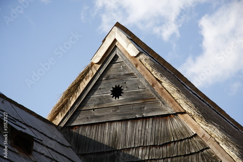 historic wooden rooftop with sun symbol © svjatogor