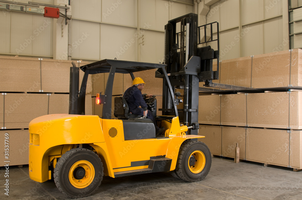Forklift operator working at warehouse.
