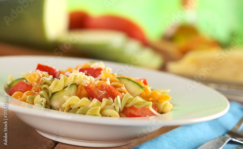 Colorful fusilli pasta with zucchini, tomato, grated cheese