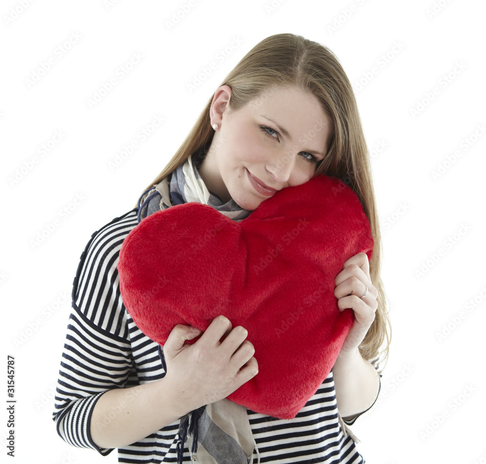 Woman cuddling with a heart pillow