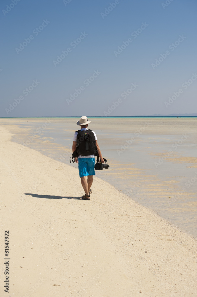 Photographer walking on a tropical beach