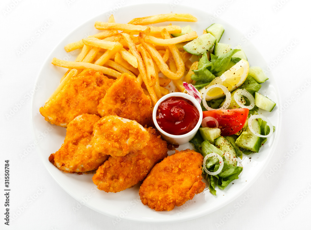 Fried chicken nuggets, French fries and vegetables Fried chicken nuggets, French fries and vegetables