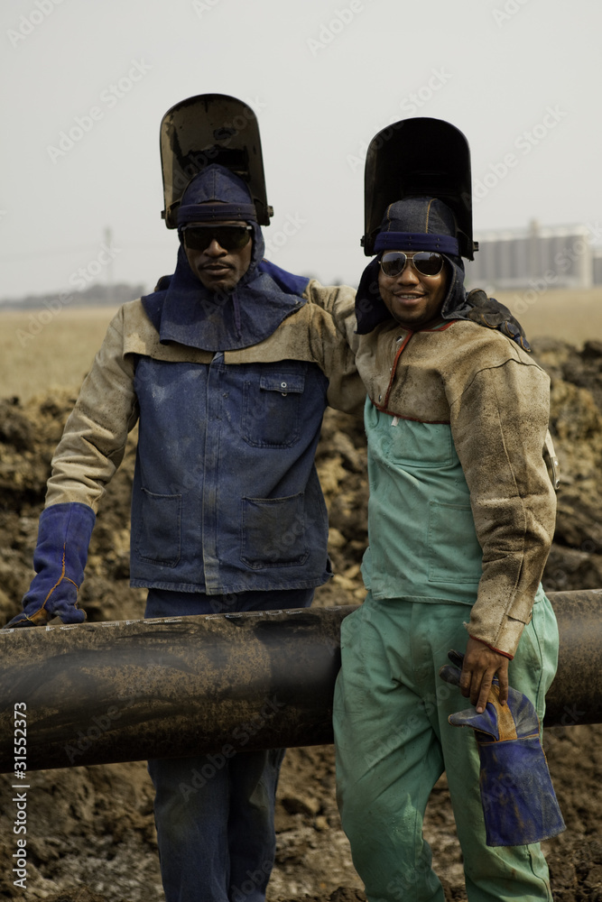 Two African American welders standing by oil and gas pipeline Two African American welders standing by oil and gas pipeline
