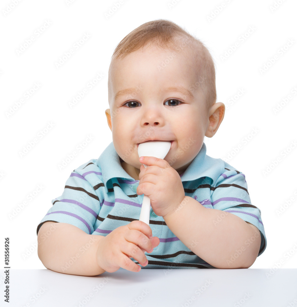 Cute little boy is biting spoon Cute little boy is biting spoon