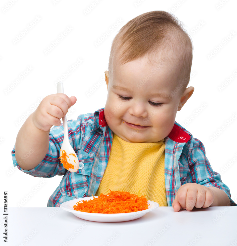 Cute little boy is playing with carrot salad Cute little boy is playing with carrot salad