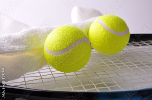 Two tennis balls and white towel on the racket isolated on white © anat_tikker